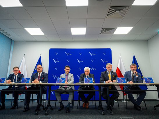 GroĂe Tunnelprojekte in Polen realisiert Sechs MĂ€nner sitzen an einem Tisch zur Vertragsunterzeichnung