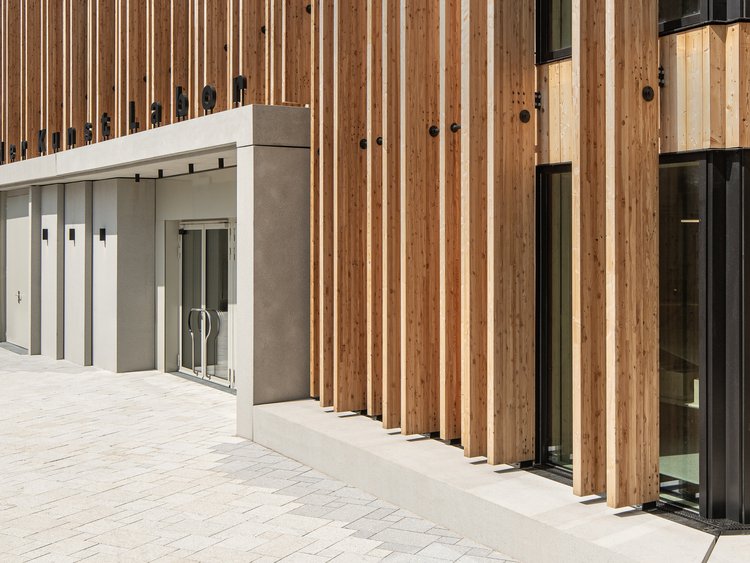 Where creativity begins. Front view of the main entrance area of a building with a wooden façade and clearly defined entrance area.